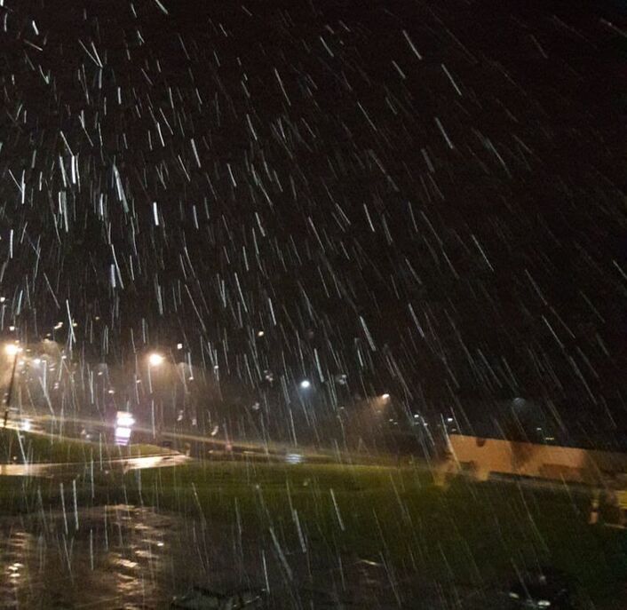 Snow falling outside at night